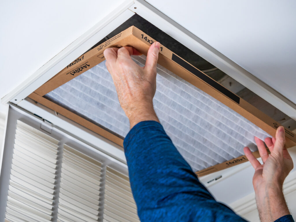 HVAC technician replacing a home air filter in Lompoc